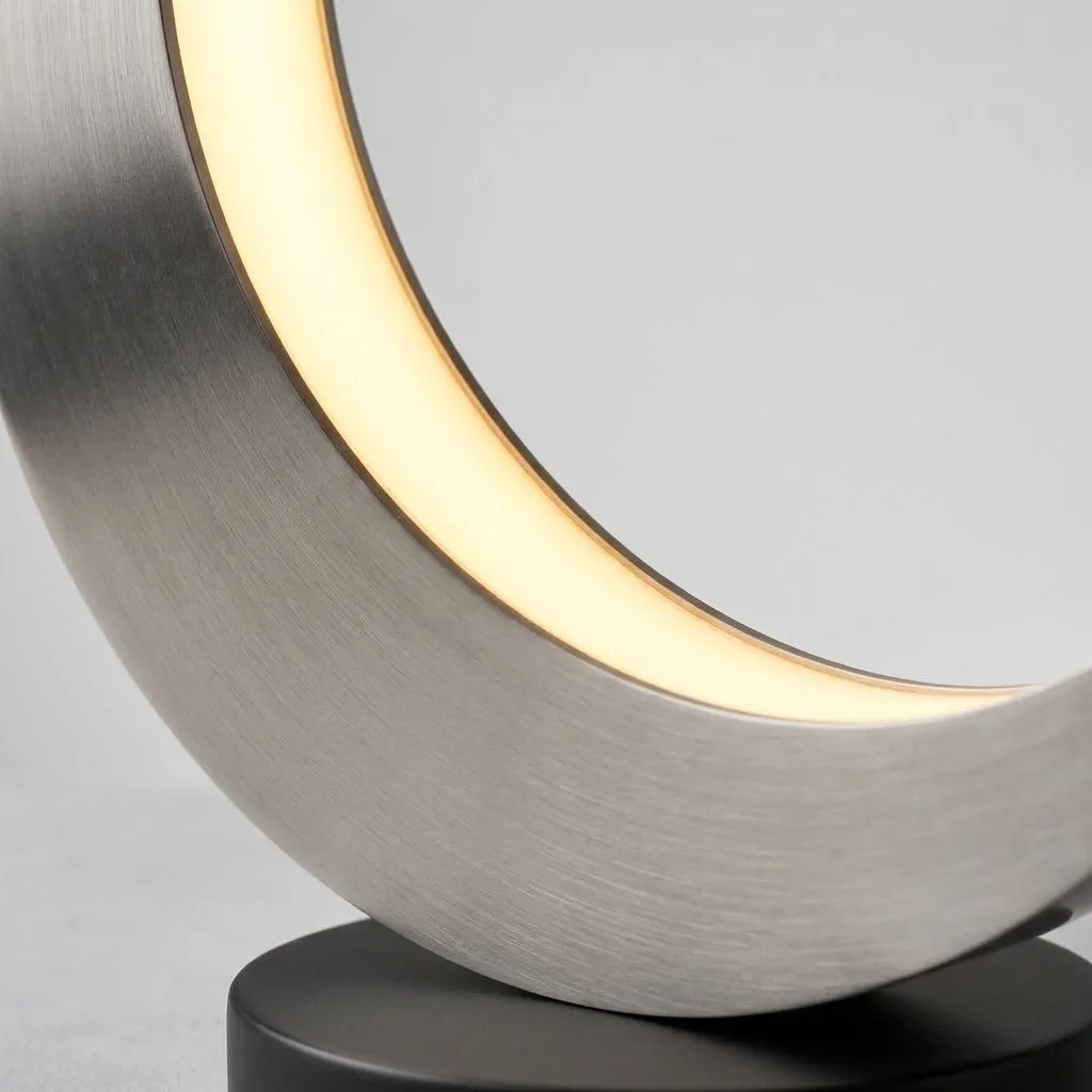 Close-up of the glowing inner edge of the brushed steel crescent