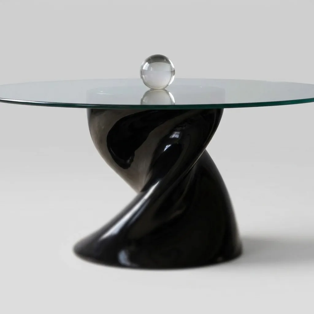 Close-up of the glass top above the glossy black twisted base