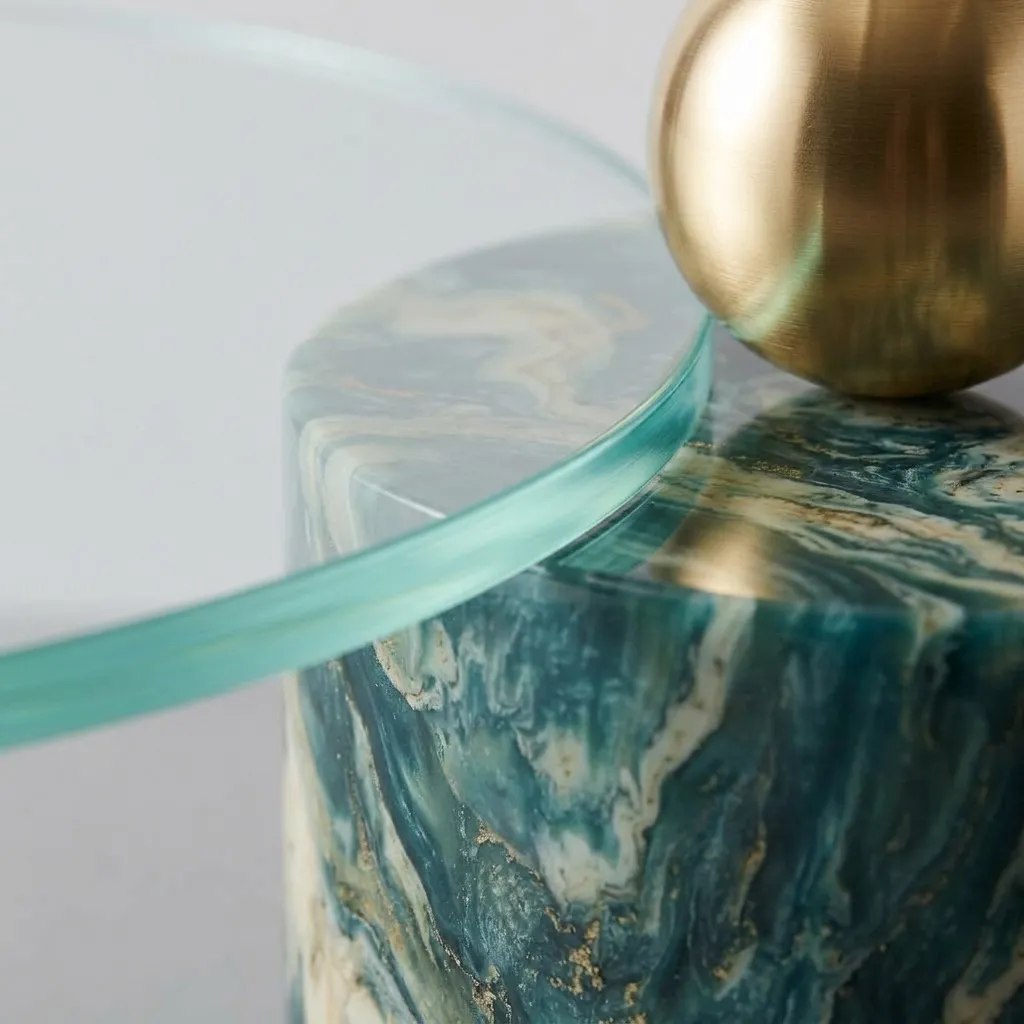 Close-up of the glass edge against the marbled resin cylinder and the brass sphere